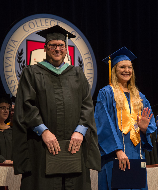 Standing beside Elliott Strickland, chief student affairs officer, Cortney L. Weaver, student speaker for Saturday morning’s ceremony, waves to her family – which only learned upon arrival of her important role.