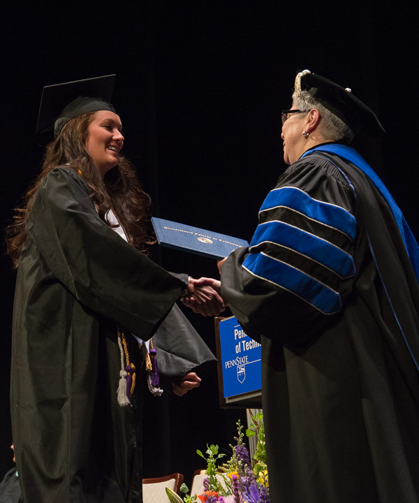 Emily K. Lutz, one of two students receiving the President’s Award for leadership and service to the college, accepts her diploma from the president. 