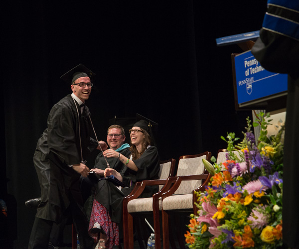 After pausing to congratulate Wiegand, Caleb G. Schirmer dashes for his diploma. The applied management graduate is a recipient of the Rose Staiman Memorial Award for brotherhood, service to college and community, and scholastic achievement. 