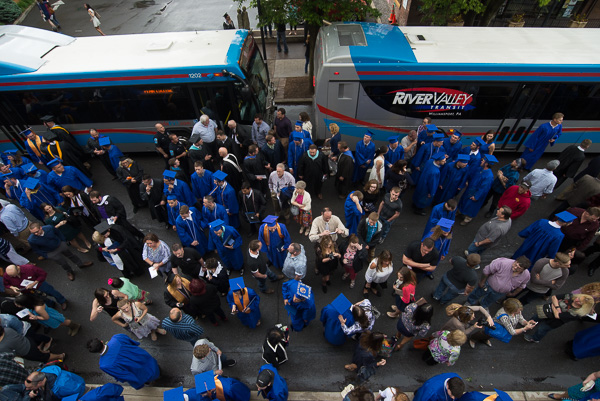 Buses await passengers following the third commencement. 