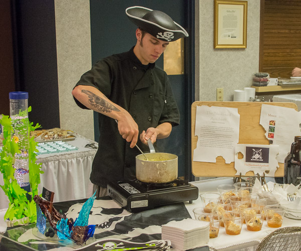 For the “Blackbeard Apaches” silver-scoring demonstration, Amy M. Decker, of Halifax, and Christopher S. Kasler, of Kendall Park, New Jersey, researched pirate cuisine. Kasler stirs grits, which shipped well for pirates.