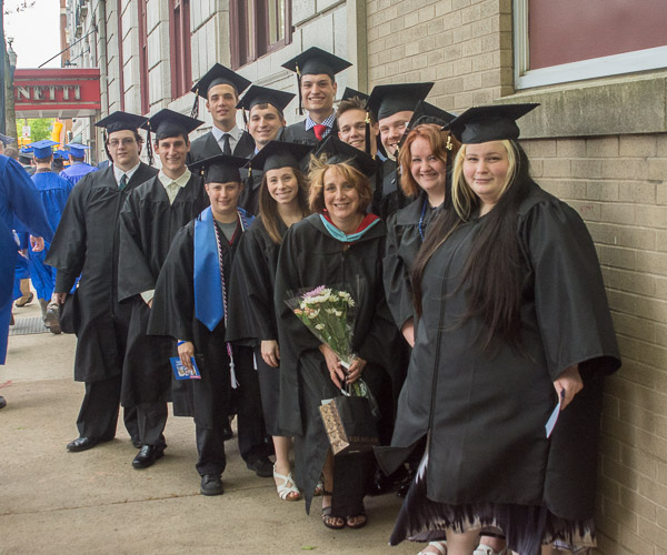 Last in line for Friday’s commencement, grads from the web and interactive media major gather for a photo with Denise S. Leete, associate professor.