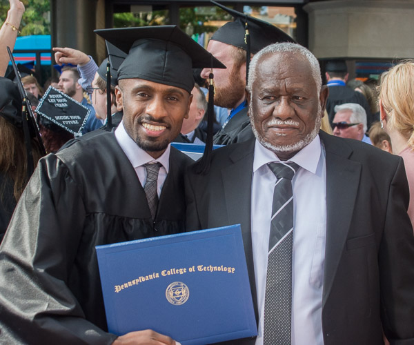 Nasser Aljadah, a plastics and polymer engineering technology graduate, celebrates with his father. 