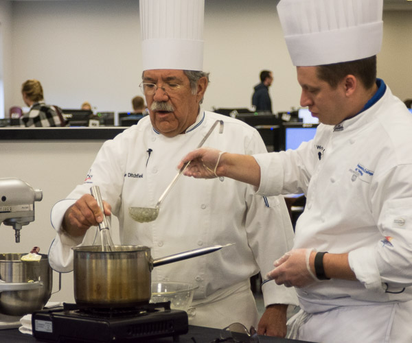 Chef Michael J. Ditchfield (left), instructor of hospitality management/culinary arts, and culinary arts and systems student Robert E. Wood, of Montoursville, provide a demo and career talk to high school students before they visit the Culinary and Pastry Experience. The high schoolers also toured campus and ate in Le Jeune Chef Restaurant.