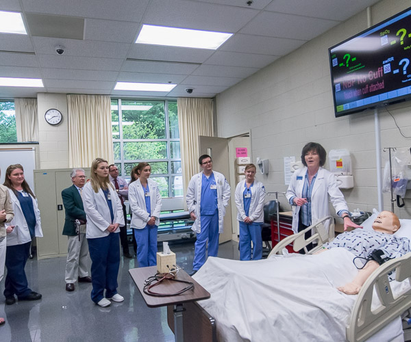 Laurie A. Minium, assistant professor of nursing, talks with guests about SimMan 3G.