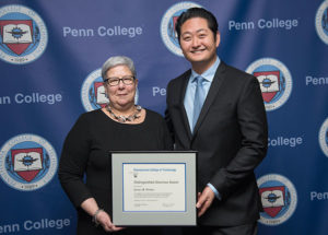 James R. Parker, of Chantilly, Va., receives the Distinguished Alumni Award from Davie Jane Gilmour, president of Penn College. Parker was raised in East Stroudsburg.