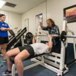 Faculty member Judy Quinti teaches form to two players – Colleen E. Bowes, of Wayne, and Lauren S. Herr of Lititz – who were interested in learning more about lifting free weights. 