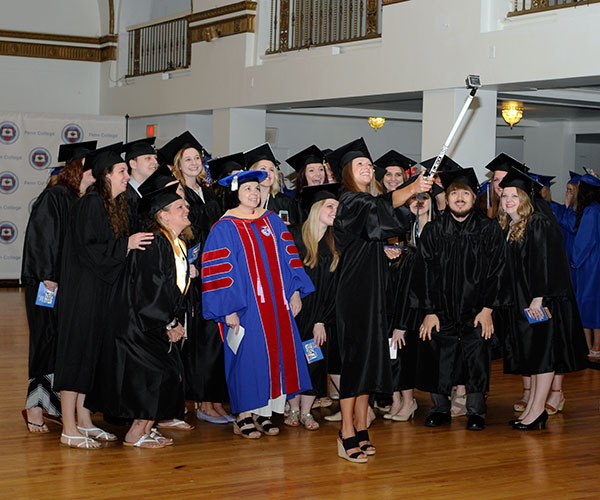 Nursing student Toncia M. Plocinski leads the charge to capture the moment; among those joining the fun is Sandra L. Richmond (in red-and-blue regalia), director of nursing.