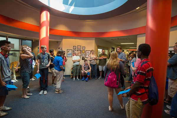 With Nicholas L. Stephenson (in plaid shirt at right), instructor of graphic design, students and their families enjoy an exhibit of the campers’ logo and stationery set projects … 