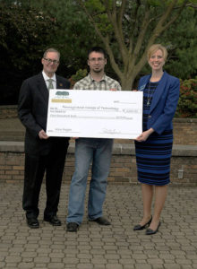 Paul Lyskava (left), executive director of the Pennsylvania Forest Products Association, presents a $1,000 donation to Erich R. Doebler, laboratory assistant for forest technology at Penn College, and Elizabeth A. Biddle, the college’s director of corporate relations.