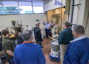 Gary E. McQuay, PIRC engineering manager, demonstrates a materials grinder in Penn College’s Rotational Molding Center of Excellence.