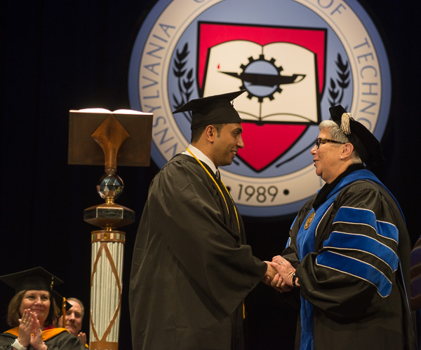 After turning the student speaker’s tassel, the college president congratulates him on a job well done. 
