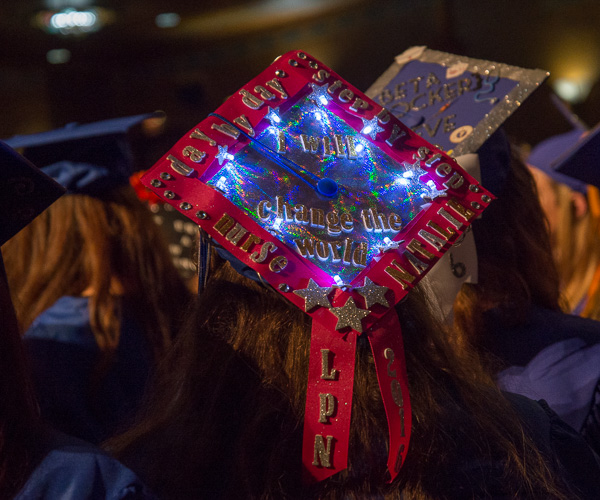 A grad's cap is aglow with the confidence of its wearer: “I will change the world.” 