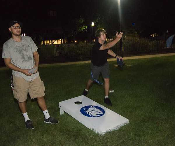 With a steady hand and studied aim, a student launches a beanbag toward the cornhole.