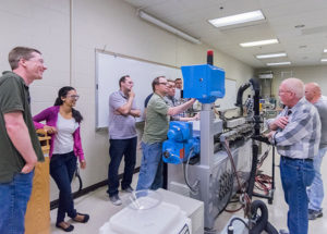 Ian C. Killian (center), a plastics and polymer engineering technology student from South Williamsport, supervises a hands-on exercise for industry professionals during the Extrusion Seminar offered by Penn College’s Plastics Innovation & Resource Center.