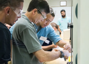 Plastics and polymer engineering technology major Noah L. Martin (third from left, in blue shirt), of South Williamsport, works closely with participants in the recent Thin-Gauge/Roll-Fed Thermoforming Workshop at Penn College.