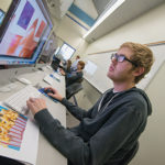 In a Penn College lab, a student polishes graphics for a class project.
