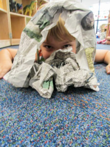 A child shows off his paper-made structure …