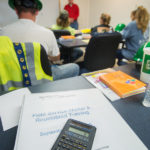 A safety vest and calculator depict the blend of skills acquired by Tuesday's graduates during their combination of classroom and on-site instruction.