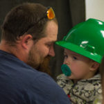 Meredith places a hard hat on his son, one of seven family members to share in the success of Meredith and his brother.