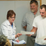 Bergquist receives his certificate from Bubb as Mendell looks on.