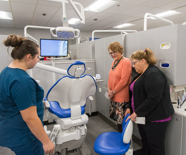 Keefer shows the workings of the new dental chairs to Dr. Julie Barna, in orange, and Faust. Faust began her career as a dental assistant in Barna’s Lewisburg office. Recognizing a gift for the field, Barna encouraged her to further her education to become a dental hygienist. “And she listened to me!” Barna said. In her late 20s when she entered the program, Faust said of now-president Gilmour, “When I came here, she gave me the positive reinforcement.” Barna and Faust have worked together for 37 years.
