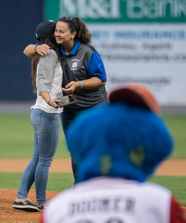 Throwing out the first pitch was Nicole C. LoFurno (left), women's softball player and North Eastern Athletic Conference Student Athletic Advisory Council Member of the Year, who was hugged on the mound by coach Jackie Klahold. 