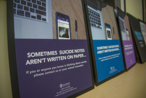 Suicide awareness posters created by Penn College student Kaelyn Y. Walker, a graphic design senior from Williamsport, line a table at a critique session. 