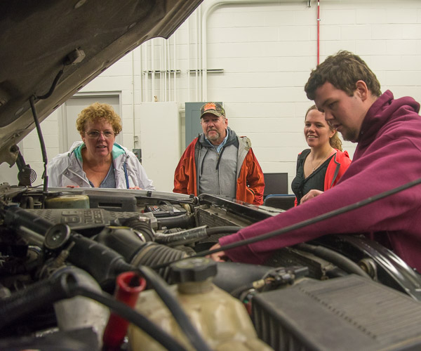 Automotive technology student James T. Wade shows his family a project he’s working on (replacing an injection pump) in the automotive labs. The family journeyed to campus from Lafayette Hill. 