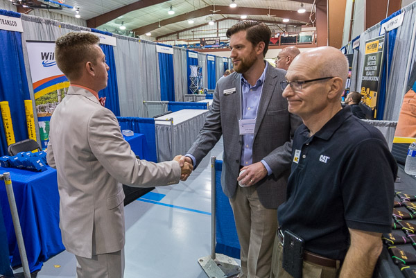 Caterpillar Inc.'s Griffin Reome talks with a prospect alongside Milton CAT's Buster Fiacco.