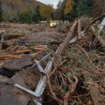 Twisted metal, fallen trees and decimated roadways are left in floodwaters' wake.