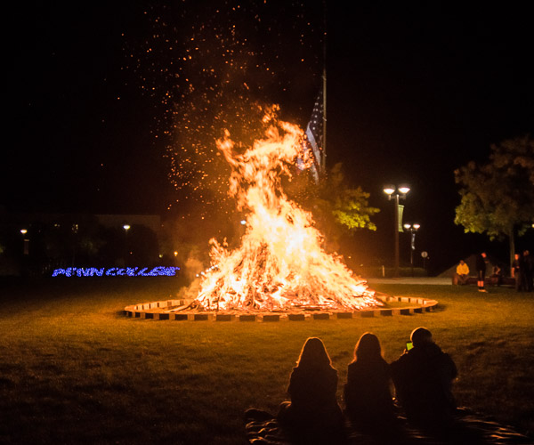 Taking some of the edge off a damp Thursday evening is the Homecoming bonfire, this year moved to the library lawn.