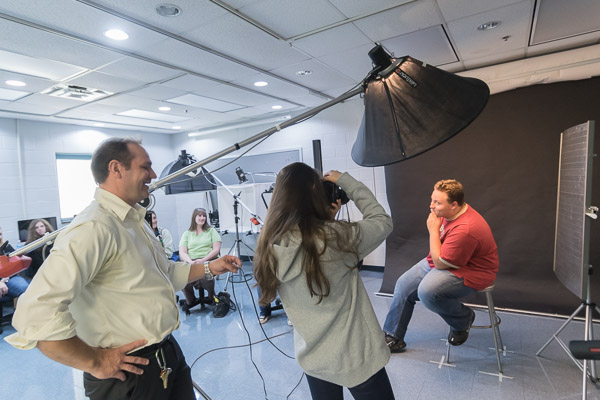 Mark W. Wilson, part-time faculty in advertising art, offers a primer on lighting (and lightheartedness) during an amiable session on portrait photography with Millville high school students.