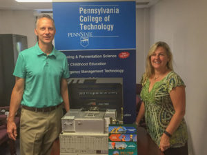 Michael J. Reed, dean of the School of Sciences, Humanities & Visual Communications at Penn College, accepts a donated PeakSimple 2000 gas chromatograph from Kate Bowes Harris, of Hilltop Enterprises, based in West Chester.