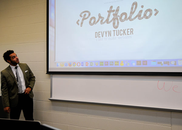 Student Devyn T. Tucker presents his portfolio to prospective web and interactive media majors.