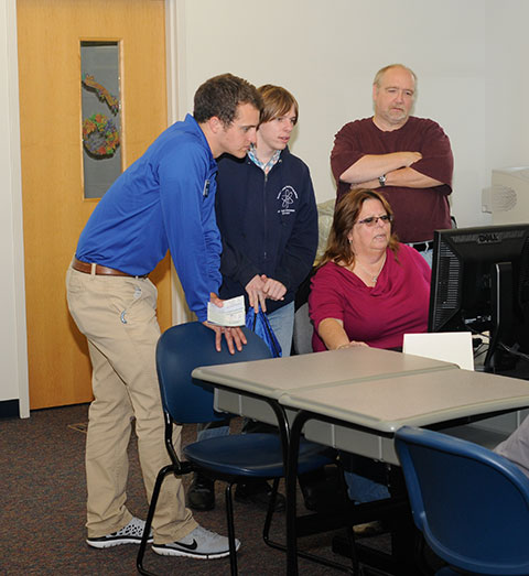 Student Ambassador Josiah D. Stoltzfus assists the online application process in the Student and Administrative Services Center.
