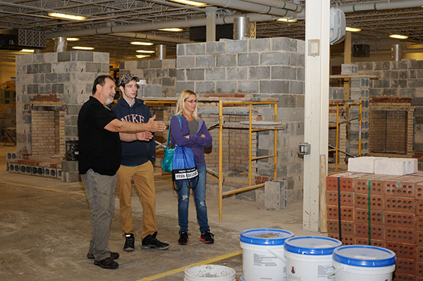 Instructor Glenn R. Luse leads a Clinton County family through the Construction Masonry Building.