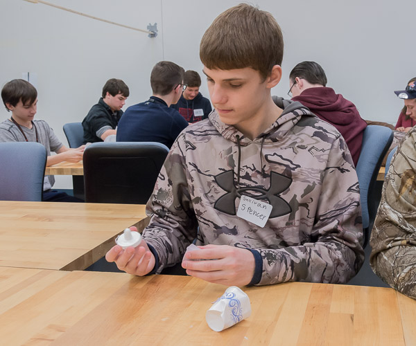 A student inspects a replica of his thumb tip.