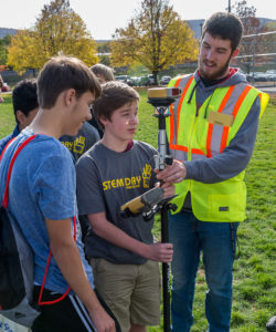 Penn College student Shawn L. Sheeley Jr., of Kersey, shows a high school student how to use surveying equipment. The hands-on workshop was part of a National STEM Day celebration at the college that brought homeschoolers and students from four area high schools to campus.