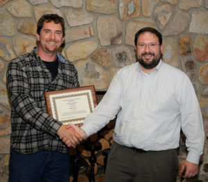 Chris S. Weaver (left), an instructor of diesel equipment technology at Penn College, accepts a plaque and congratulations from past recipient Justin W. Beishline, assistant dean of transportation and natural resources technologies.
