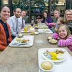 Employees of the college's Admissions Office join family and friends for a festive meal.