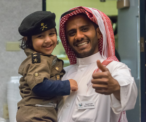 Plastics major Yousef I. Asiri lifts a young friend (and raises his thumb) at the successful Saudi Expo.