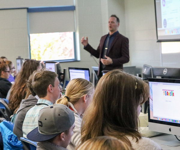 Spyke M. Krepshaw, instructor of web and interactive media, leads high-schoolers through a hands-on session to build an e-commerce website.