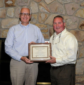 Brett A. Reasner, dean of transportation and natural resources technologies, presents 20-year participation honors to Ron Garber, of Ransome CAT ...