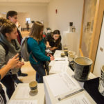 Activity is brisk at the silent bidding station for the one-of-a-kind clay mugs being auctioned to benefit the Penn College Employee Emergency Fund. 