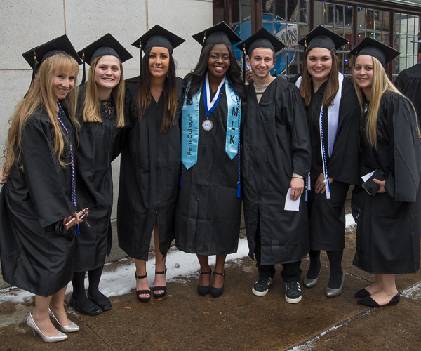 A group huddle keeps these graduates warm on their walk from The Genetti to the Arts Center. 
