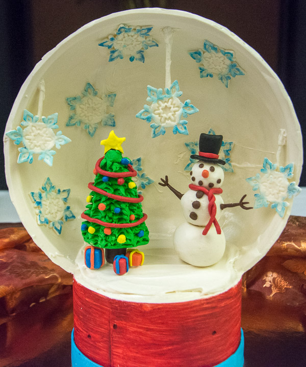 Snowflakes fall ‘round a snowman in a chocolate snow-globe vignette that earned second place for Alexis L. Kepley in Principles of Chocolate Works.