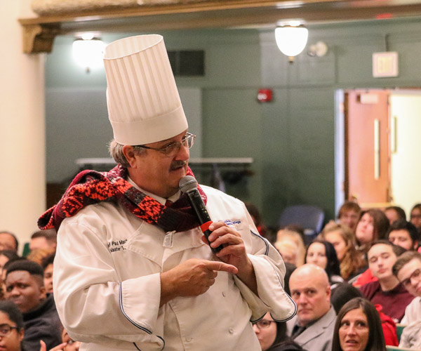 Chef Paul Mach, “You’re the Chef” co-host and assistant professor of hospitality management/culinary arts, warms up the crowd in the Academic Center Auditorium. The audience is made up of high school students who attended a presentation on modernist cuisine before touring the facilities for hospitality majors and attending the Food Show.