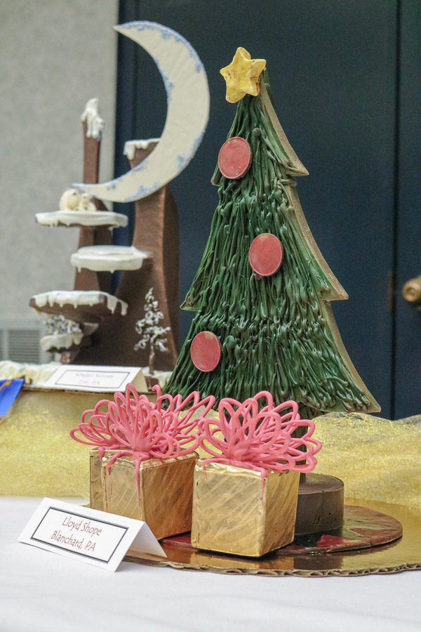 Gifts beneath Lloyd A. Shope’s chocolate tree beckon Christmas daydreams.