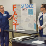 Nursing students Alexis E. Jones (left), of Watsontown, and Brittney J. Barrett, of Mill Hall, review signs that a loved one has had a stroke, FAST: Face drooping, Arm weakness and Speech difficulty, followed by Time to call 911.